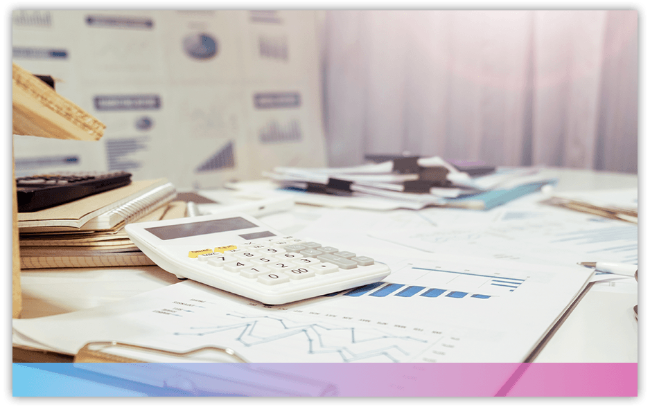 A calculator and documents laid out across a desk
