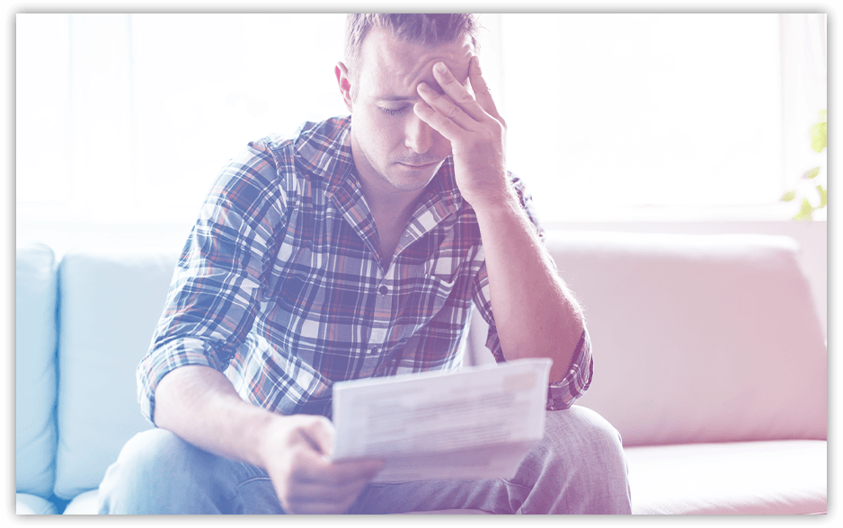 A man looking dejected over a piece of mail