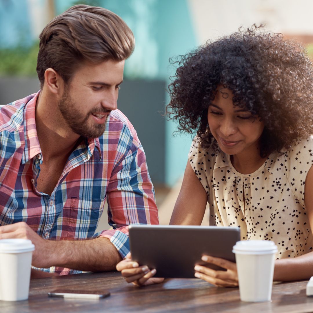 people looking at a tablet happily