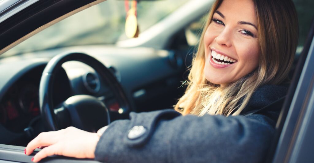 Woman smiling in a car with the window down