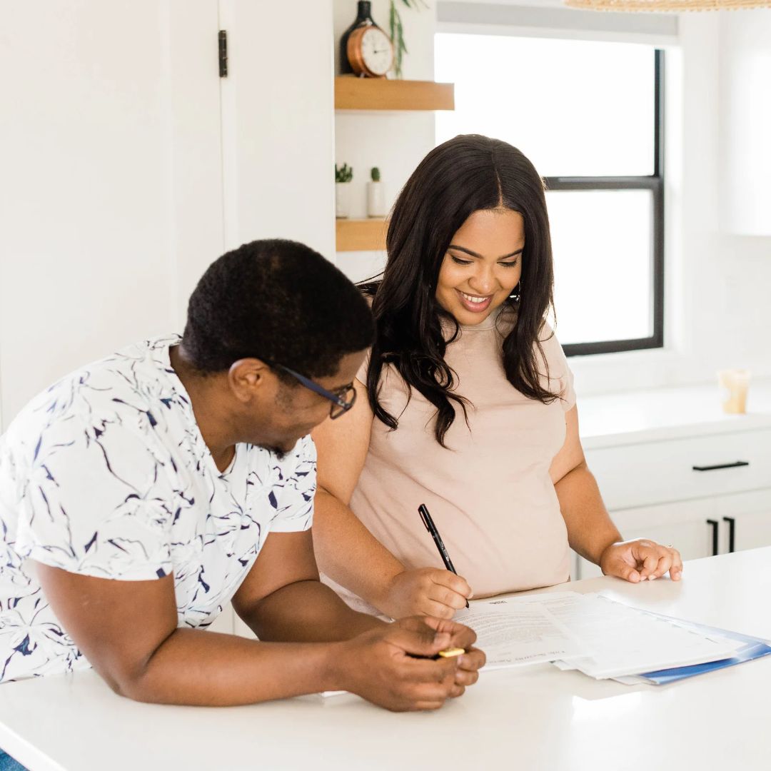 Two people looking at paperwork at a kitchen counter