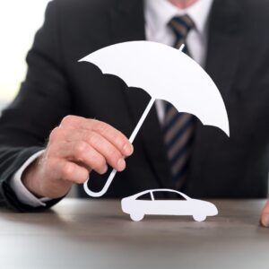 person holding toy umbrella over toy car
